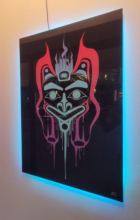 photo of the Tlingit formline artwork with neon lighting behind it