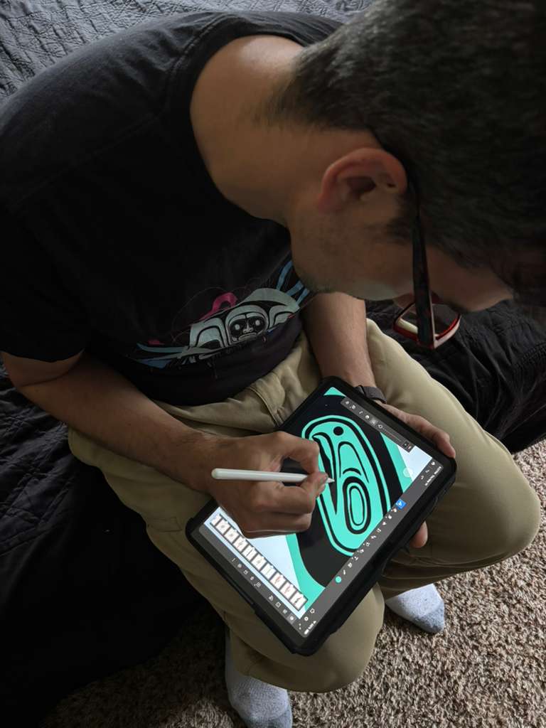 Artist seated, drawing a large teal ovoid form on an iPad with an Apple Pencil. The teal and black composition fills the screen